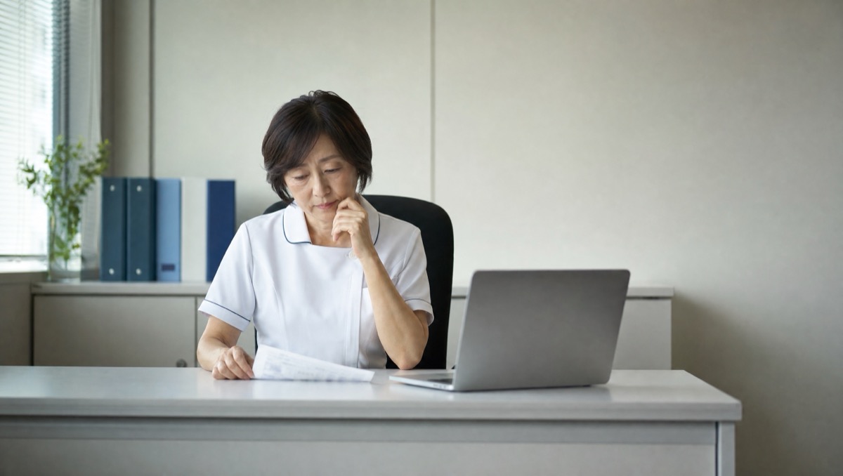 病棟の配属表を確認する看護部長らしき人物のイメージ